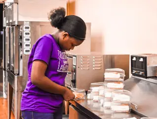 Young team member preparing homemade desserts at Laila’s Place in Newberry, SC
